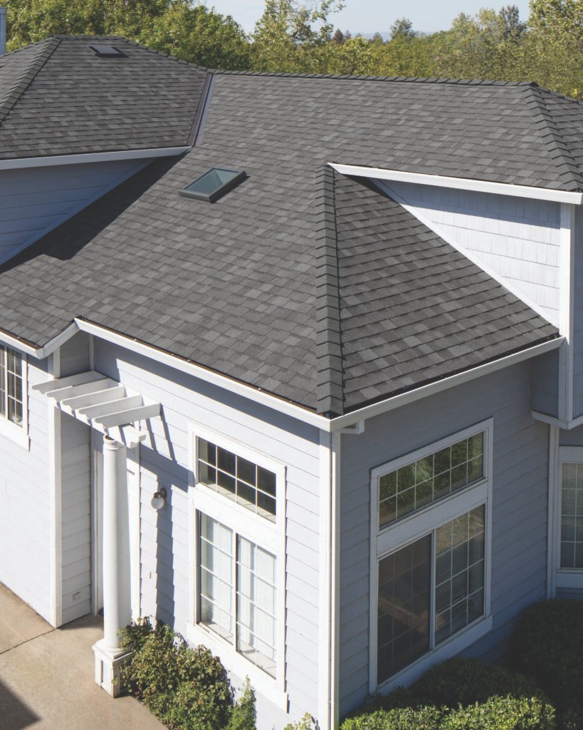 A two-story house in Houston, Texas, featuring a newly repaired roof with dark grey architectural shingles.