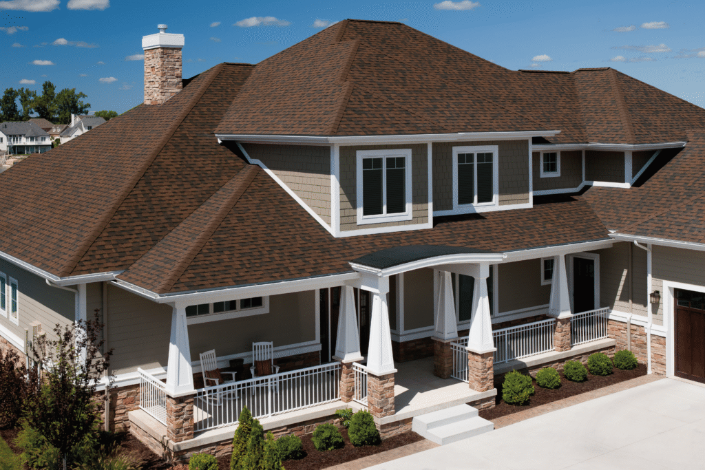 Comprehensive residential roofing services on a large home with brown architectural shingles in Houston.