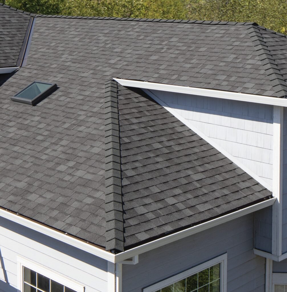 Residential roof leak repair near valley and skylight on grey shingles in Houston.